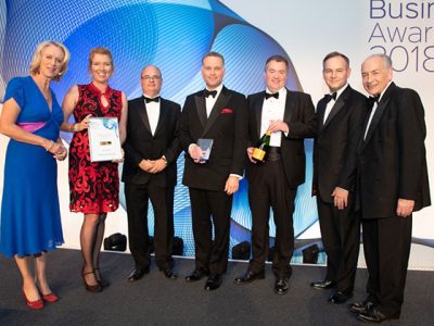 Group of people in formal attire at an event for Business Awards 2018.