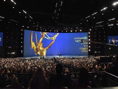 Award ceremony stage with a large Emmy statue graphic and text for a comedy series category.