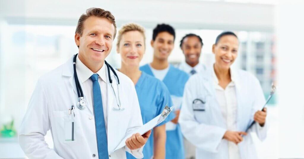 Group of medical professionals in white coats with stethoscopes.